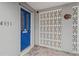 Bright blue front door with mid-century modern details, white brick, and decorative sun adding to the home's curb appeal at 4931 Pelican Dr, New Port Richey, FL 34652