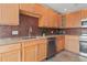 Close up of kitchen featuring granite countertops, stainless steel appliances, light wood cabinets, and mosaic tile backsplash at 4931 Pelican Dr, New Port Richey, FL 34652