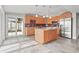 Well-lit kitchen featuring light wood cabinetry, stainless steel appliances, an island, and a door to the patio at 4931 Pelican Dr, New Port Richey, FL 34652