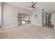 Large living room features neutral carpet, access to pool, and access to guest bathroom at 4931 Pelican Dr, New Port Richey, FL 34652