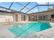Enclosed swimming pool featuring a screen enclosure, clear blue water, and plenty of sunlight for outdoor relaxation at 4931 Pelican Dr, New Port Richey, FL 34652