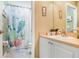Bathroom featuring a vanity with a sink, a decorative mirror, and a cactus-themed shower curtain at 5013 119Th E Ter, Parrish, FL 34219