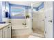 Clean bathroom features a tiled tub, frameless glass shower, and vanity with a window for natural light at 5013 119Th E Ter, Parrish, FL 34219