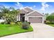 Single-Gathering home with lush landscaping and a spacious driveway leading to a two-car garage at 5013 119Th E Ter, Parrish, FL 34219