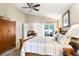 Bright main bedroom with a wooden bed, ceiling fan, and access to both the living room and backyard at 5013 119Th E Ter, Parrish, FL 34219