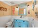 Charming beach-themed bathroom with blue vanity, white walls, and nautical decor at 5657 Oceanic Rd, Holiday, FL 34690