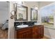 Bright bathroom featuring dual sinks with black granite counters and custom framed mirrors at 5657 Oceanic Rd, Holiday, FL 34690