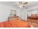 Bright bedroom with wood floors, ceiling fan, and a mirrored closet showcasing a comfortable bed at 5657 Oceanic Rd, Holiday, FL 34690