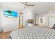 Bright bedroom with flat screen TV and ensuite bath featuring wood flooring, fireplace, and ceiling fan at 5657 Oceanic Rd, Holiday, FL 34690
