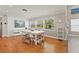 Bright dining room with hardwood floors, large windows, and modern white table set at 5657 Oceanic Rd, Holiday, FL 34690