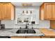 Close-up of a kitchen sink area featuring unique lighting and granite countertops at 5657 Oceanic Rd, Holiday, FL 34690