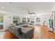 Spacious living room with hardwood floors, fireplace, ceiling fans, and large gray sofa at 5657 Oceanic Rd, Holiday, FL 34690