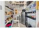 Organized pantry with ample shelving, ladder, stainless steel refrigerator, and storage containers at 5657 Oceanic Rd, Holiday, FL 34690