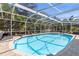Enjoy the refreshing screened-in pool surrounded by lush greenery and outdoor furniture at 5657 Oceanic Rd, Holiday, FL 34690