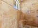 Tile shower featuring multiple shower heads, stone flooring, and built-in tiled corner shelves at 5657 Oceanic Rd, Holiday, FL 34690