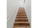 Stairway with wood steps and a white railing in a well-lit home at 5657 Oceanic Rd, Holiday, FL 34690