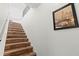 Stairway with wood steps and a picture hanging on the wall at 5657 Oceanic Rd, Holiday, FL 34690