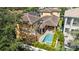 Aerial view of private pool, brick patio, tiled roof, and manicured landscaping at 6113 Yeats Manor Dr, Tampa, FL 33616