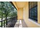 Private balcony featuring black metal railing and views of mature shade trees at 6113 Yeats Manor Dr, Tampa, FL 33616