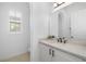 Bathroom with quartz countertop vanity, modern hardware, and natural light from a shuttered window at 6113 Yeats Manor Dr, Tampa, FL 33616
