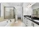 Bright bathroom with dual sinks, soaking tub, and walk-in shower with neutral tile at 6113 Yeats Manor Dr, Tampa, FL 33616
