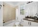 Functional bathroom with tub shower combo, ceramic tile, and white vanity at 6113 Yeats Manor Dr, Tampa, FL 33616
