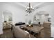 Dining room with modern chandelier, large table, and open access to the living room at 6113 Yeats Manor Dr, Tampa, FL 33616