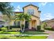 Charming two-story home featuring a manicured lawn and lush landscaping with palm trees at 6113 Yeats Manor Dr, Tampa, FL 33616
