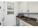 Bright laundry room with white cabinetry, quartz countertops, stainless steel appliances, and natural light at 6113 Yeats Manor Dr, Tampa, FL 33616