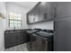 Laundry room with modern appliances, stylish tile flooring, and ample storage in gray cabinetry at 6113 Yeats Manor Dr, Tampa, FL 33616