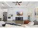 Living room featuring comfortable seating, a modern entertainment center, and natural light from shuttered windows at 6113 Yeats Manor Dr, Tampa, FL 33616