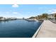 A waterfront view featuring yachts docked alongside a pier with a building and palm trees in the background at 6113 Yeats Manor Dr, Tampa, FL 33616
