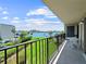 Balcony overlooking lush green grass, a swimming pool, and a view of the ocean at 650 Island Way # 408, Clearwater Beach, FL 33767