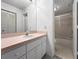 Neutral bathroom with a single sink vanity, large mirror, and a shower-tub combo with sliding glass doors at 650 Island Way # 408, Clearwater Beach, FL 33767