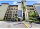 Multi-story condo building with balconies, tropical landscaping, and convenient elevator access at 650 Island Way # 408, Clearwater Beach, FL 33767