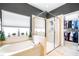 A full bathroom features a soaking tub and shower combo, a window, and a walk-in closet at 8814 N River Rd, Tampa, FL 33635
