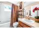 Bathroom featuring decorative shower curtain, vanity and decorative shelving at 8814 N River Rd, Tampa, FL 33635