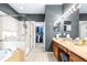 Full bathroom with a large tub, glass enclosed shower and dual sink vanity at 8814 N River Rd, Tampa, FL 33635