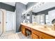 Bathroom with a double vanity, a glass-enclosed shower, and a bright lighting fixture above the mirror at 8814 N River Rd, Tampa, FL 33635