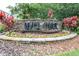 Elegant stone community entrance sign with colorful landscaping at 8814 N River Rd, Tampa, FL 33635