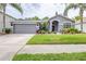 Charming single-story home featuring a well-manicured lawn, palm trees, and a two-car garage at 8814 N River Rd, Tampa, FL 33635