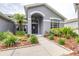 Charming home entrance featuring a decorative wreath, sidelights, and a covered porch at 8814 N River Rd, Tampa, FL 33635