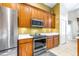 Kitchen featuring stainless steel appliances and wooden cabinets with stone countertops at 8814 N River Rd, Tampa, FL 33635