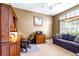 Office with custom built-ins, desk, sofa and large bright window at 8814 N River Rd, Tampa, FL 33635