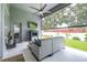 Relaxing screened patio with ceiling fan, outdoor seating, and tv for entertainment at 8814 N River Rd, Tampa, FL 33635