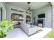 Relaxing covered patio features a ceiling fan, outdoor fireplace, and comfortable seating area at 8814 N River Rd, Tampa, FL 33635