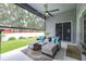 Comfortable screened patio with ample seating, ceiling fan, overlooking the backyard at 8814 N River Rd, Tampa, FL 33635