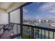 Cozy balcony with wicker furniture and scenic views of the marina and waterfront at 9525 Blind Pass Rd # 505, St Pete Beach, FL 33706