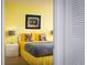 Vibrant bedroom with sunny yellow walls and fun, colorful decor at 9525 Blind Pass Rd # 505, St Pete Beach, FL 33706