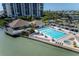 Aerial view of a large pool with sun loungers and umbrellas next to the Condo building at 9525 Blind Pass Rd # 505, St Pete Beach, FL 33706